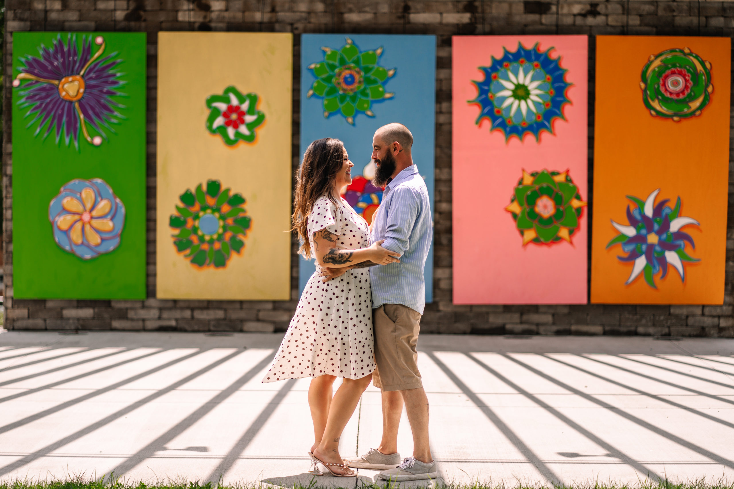 Engagement session in front of multi-colored art installment. 