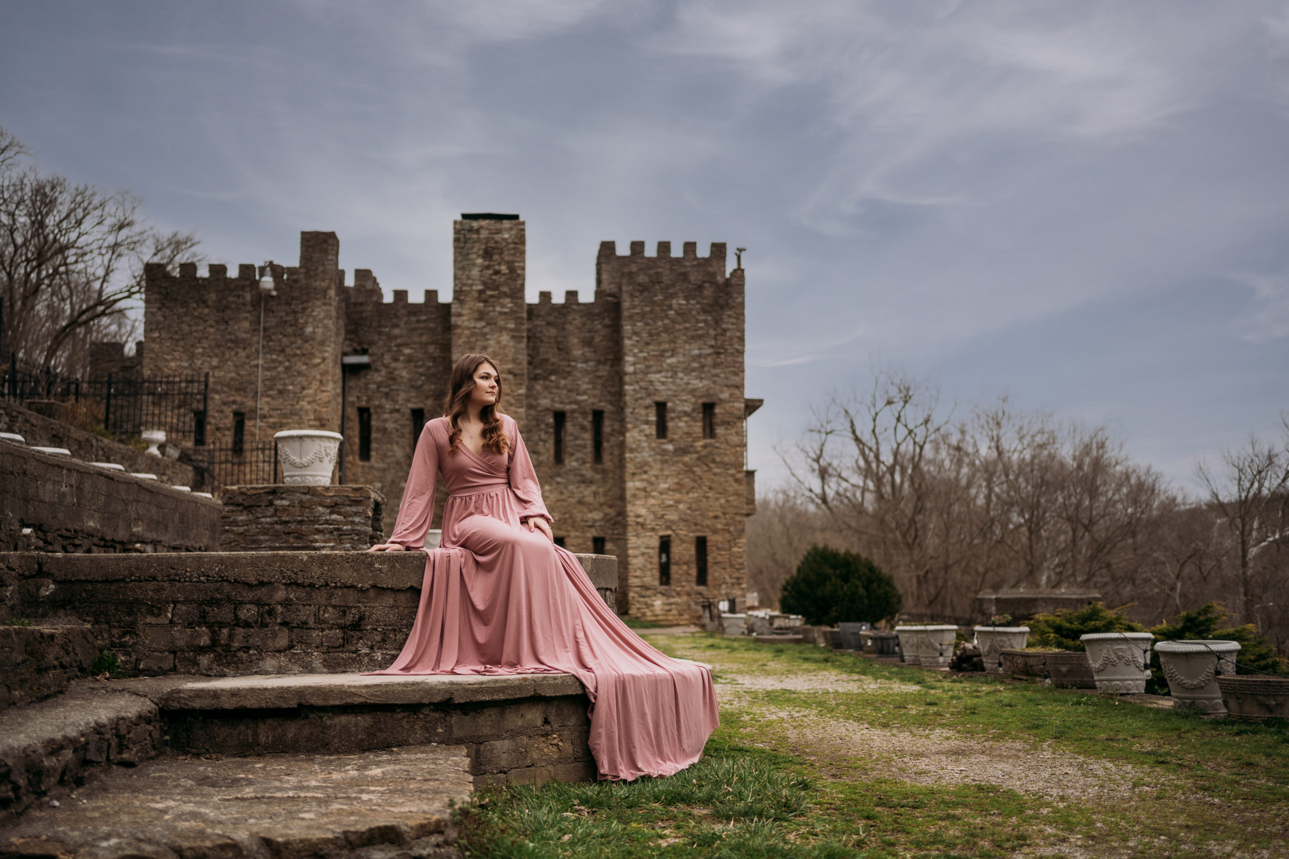 Loveland Castle Senior Session. Flowy dusty rose gown in the gardens. Sitting on stone steps with castle in background