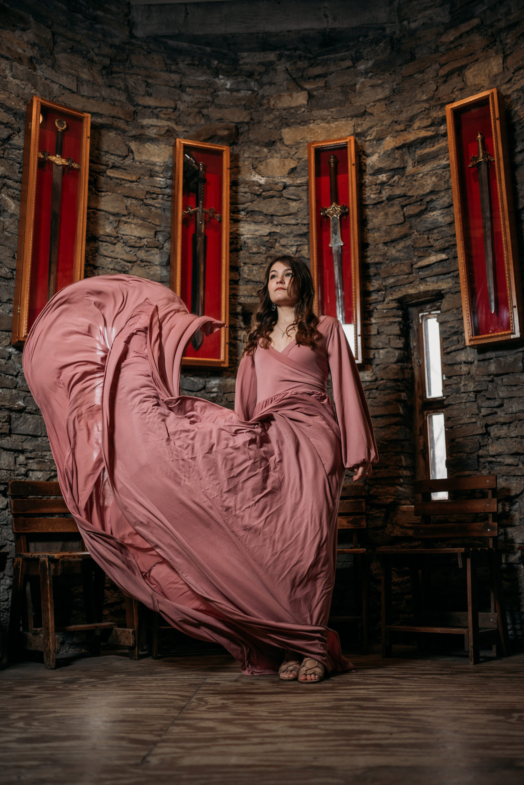 Loveland Castle Senior Session. Flowy dusty rose gown in the gardens. Standing in sword display room